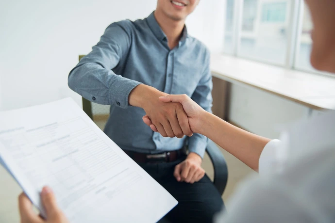 Dos personas dándose la mano tras una entrevista